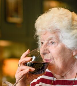 seniorka pije víno