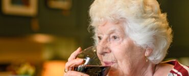 seniorka pije víno