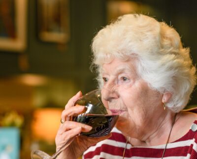 seniorka pije víno